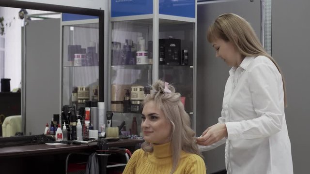 Positive Woman Hairdresser Make A Voluminous Beautiful Hairstyle