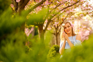 Obraz premium Outdoor fashion photo of young beautiful lady surrounded spring leaves