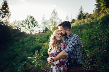 Fototapeta premium Young couple in love outdoor. Travelers couple look at the mountain.