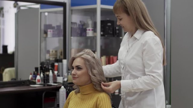 Positive Woman Hairdresser Make A Voluminous Beautiful Hairstyle