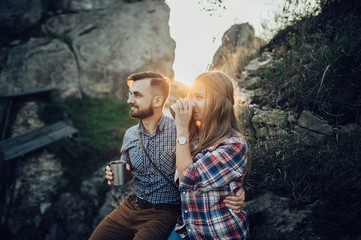 Hipster couple in love having fun together posing in mountain.
