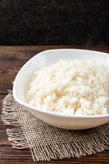 Rice porridge on dark wooden background.