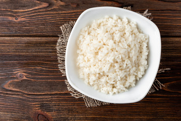 Rice porridge on dark wooden background.