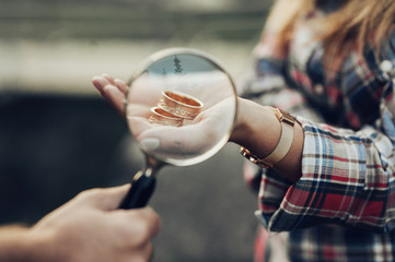 Beautiful Young Couple walks in mountain,  having fun and kissing. Close up of woman's hand holding rings. 