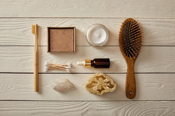 top view of various hygiene and cosmetic items on white wooden surface, zero waste concept