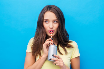 people concept - smiling young woman or teenage girl in yellow t-shirt drinking soda from can...