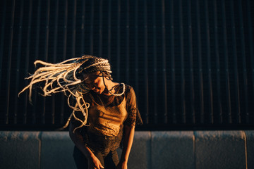 Smiling teenage girl dancing with tousled long hair at skateboard park