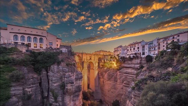 Timelapse of the Puente Nuevo bridge and the houses built on the edge of the cliff at dusk, in the ancient city of Ronda, Spain.