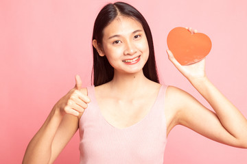 Asian woman thumbs up with red heart.