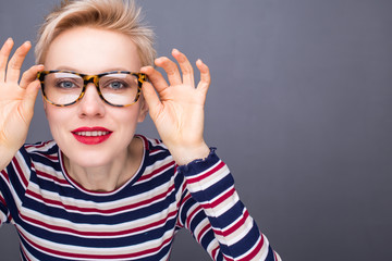 Beauty portrait of a young caucasian healthy woman holding glasses and looking at camera