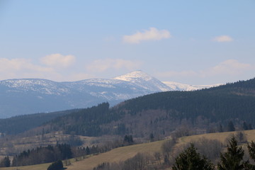 Rudawy Janowickie Mountains during spring. Karkonosze Mountains, Śnieżka Mountain (snow-covered) in the background. Warm, sunny, calm day. Sudety. Lower Silesia, Dolny Śląsk, Poland, Polska, Polen