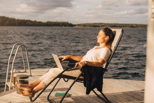 Side view of woman relaxing on deck chair