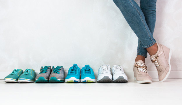 Several Pairs Of Sports Shoes And Legs.