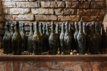 Old wine bottles on the shelf in the wine cellar
