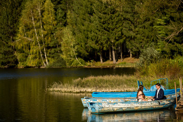 Obraz premium Wedding couple posing on boat in river