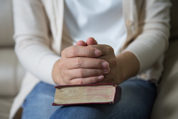Obraz premium Hands of an unrecognizable woman with Bible praying