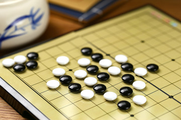 Chinese go game board, close up view of playing black and white stone pieces