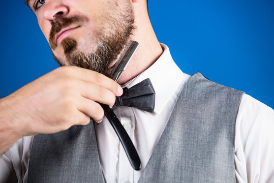 Shaping his beard. Hipster with retro razor for shaving beard. Barber with vintage barber tool. Razor barber shop. Bearded man with razor in barbershop. Brutal man with beard holding shave razor