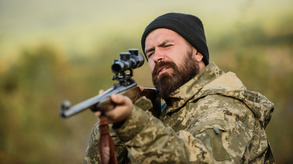 On my target. Bearded hunter spend leisure hunting. Hunting optics equipment for professionals. Brutal masculine hobby. Man aiming target nature background. Hunter hold rifle aiming. Aiming skills