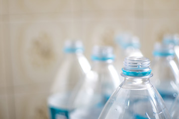 Pack of transparent empty pet plastic water botles with blue label, no cap and blurred background