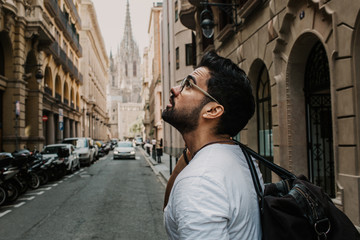 Traveler male discover a big europe city, travel and active lifestyle concept.Bearded Tourist Man with black leather bag enjoy beautiful city travel. Cropped