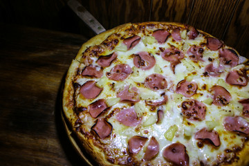Hawaiian Pizza on a wooden tray on the table 