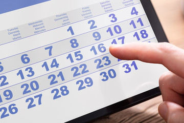 Businessperson Looking At Calendar On Tablet