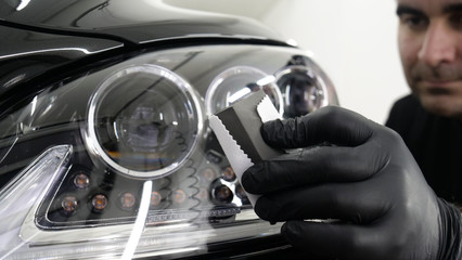 Professional ceramics handler apply different layers to the car using an applicator (sponge, fiber) immediately checking the effect. Concept from: Autodetailing, Special Ceramics, Nano technology.