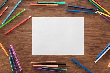 blank paper with color pencils and felt pens on wooden brown surface, lgbt concept