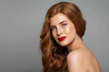 Pretty redhead woman face. Red head girl with curly hairstyle. Ginger hair, red lips makeup. Natural authentic beauty