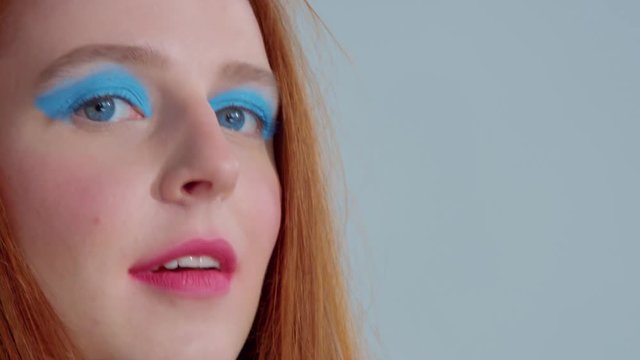 hand close to eyes gesture with bright pop up makeup blue eyes