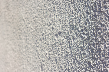 Texture of decorative plaster with a relief. White plaster. Abstract background. Small depth of field. Close-up.