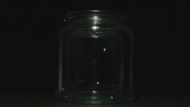 SLOW MOTION:&nbsp;Couscous grains pouring into a glass jar