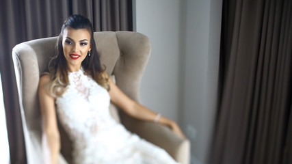 Naklejka premium Beautiful girl posing on armchair in luxury room
