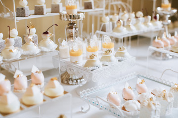 Wedding reception dessert table with delicious decorated white cupcakes 