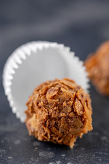 Hand-made candy with cognac, raisins and sweet topping. andy on a dark background.