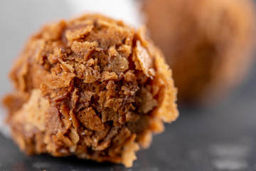  hocolates with raisins and cognac and liqueur and cocoa. Homemade candy on a dark background. Macro.