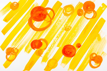 Top view of orange circles and yellow brushstrokes on white background
