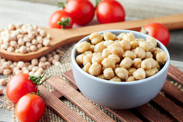 Cooked chickpeas (Cicer arietinum) in bowl on wooden background