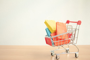 Colorful paper shopping bags in a trolley or shopping cart,E-commerce concept.