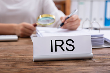 Nameplate With IRS Title Kept On Businesswoman's Desk