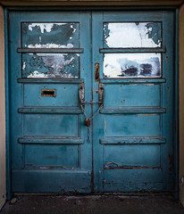 Close up on Boarded up doors to abandoned building, grungy textured background