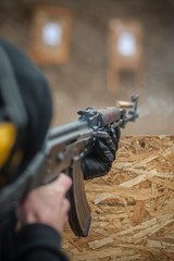 Combat riffle machine gun shooting from behind cover or barricade