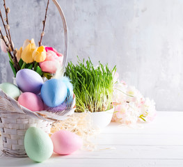 Easter basket filled with colorful hand painted Easter Eggs over a light background
