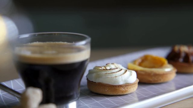 Coffee cup with delicious bitesize French cakes