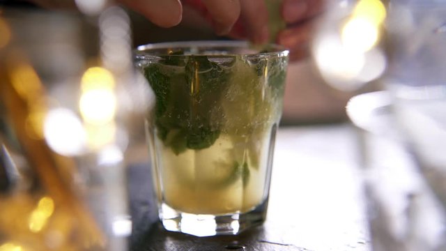 Close up of fresh mojito cocktail being garnished