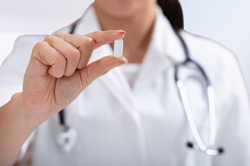 Female Doctor Holding White Tablet In Hand