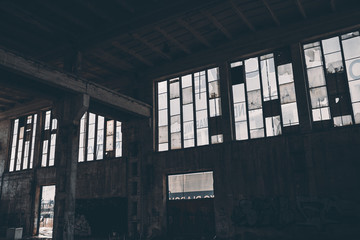 Industrial interior of an old factory building with big windows