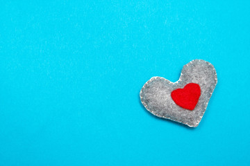 Felt handmade heart on a blue background. Top view.