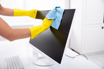 Person's Hand Cleaning Desktop Screen